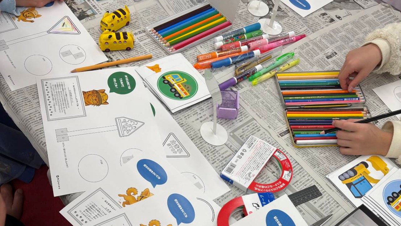色鉛筆やペンでオリジナル標識をつくる子どもたち
